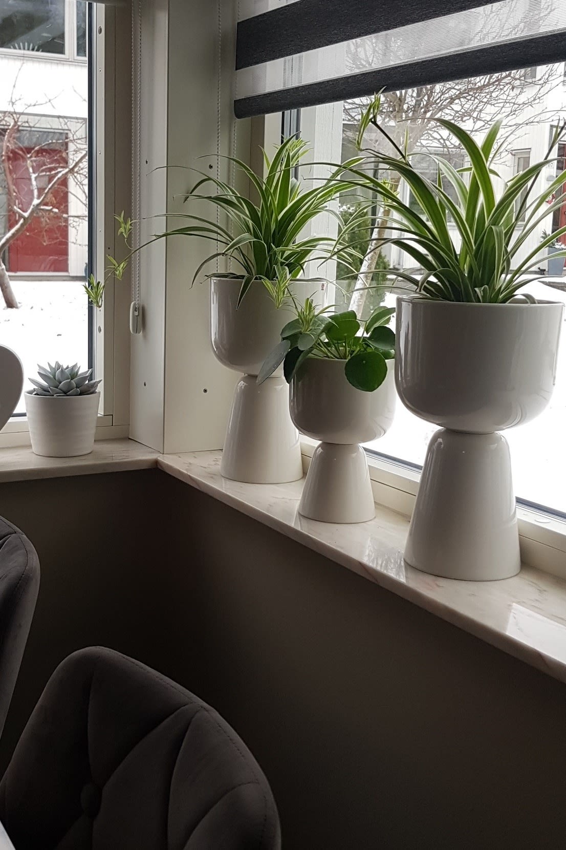 The windowsill of @mahnaz's corner window is decorated with several flowers in the Nappula flower pots from Iittala.