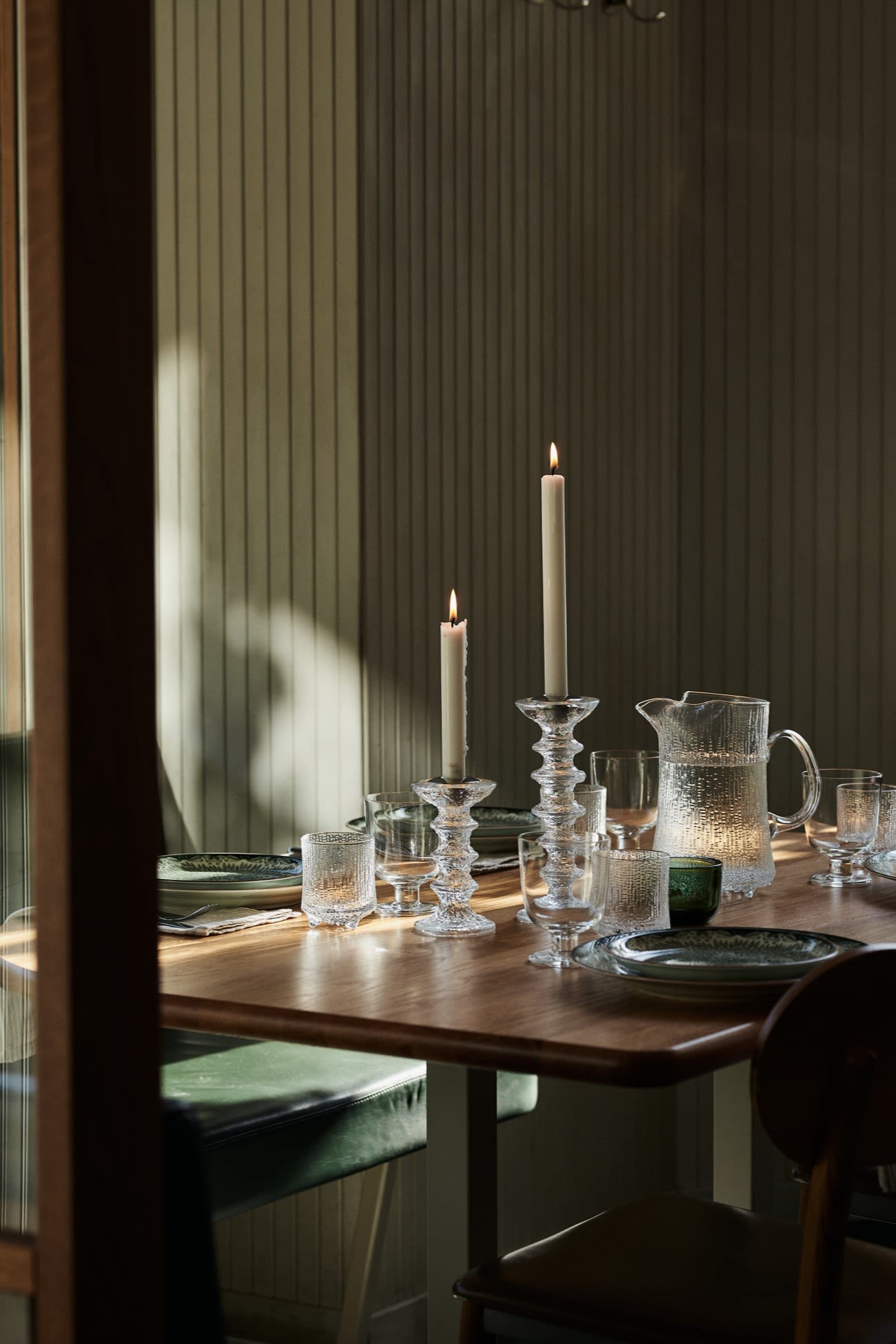 Here you see a green table setting idea in a restaurant environment with chunky glass candle holders and matching water jug. 