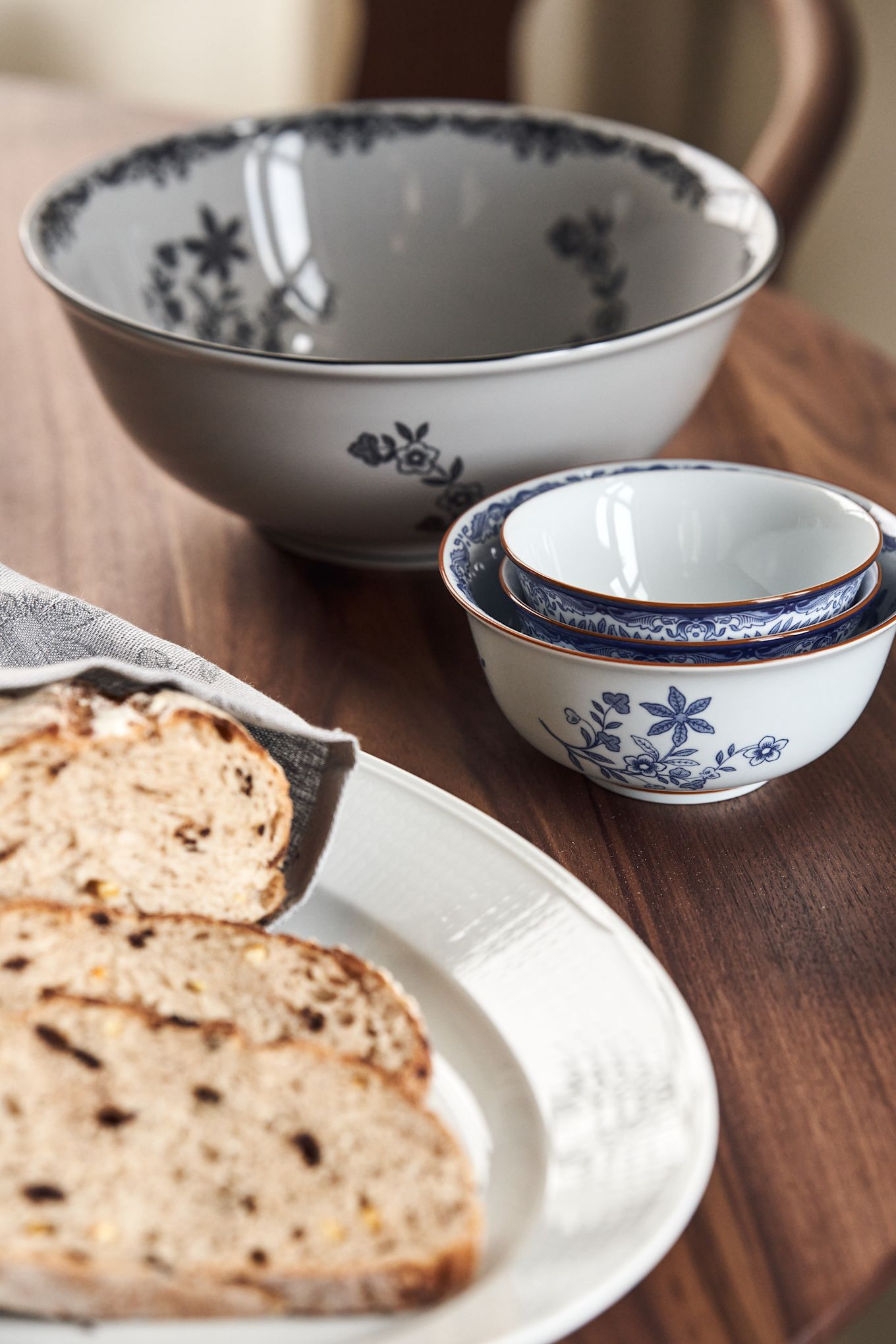 Ostindia large bowl in black and small bowls in blue, on a rustic table. 