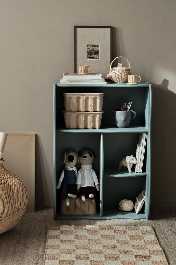 A bookshelf is a great idea for your children's room. Here you see the Slope bookshelf in blue with books and storage boxes. 