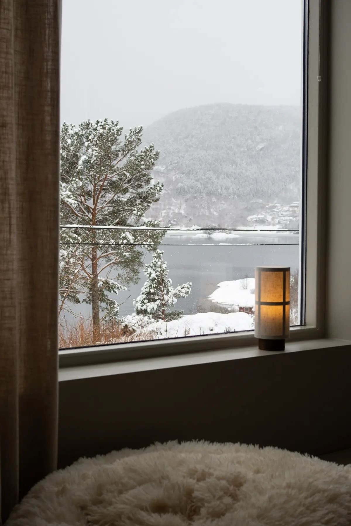 If you like it minimalist, you can also simply place a single table lamp on the windowsill. Here you can see the portable Hashira table lamp from Audo Copenhagen on @regineforsund's windowsill, with a snow-covered landscape behind it.