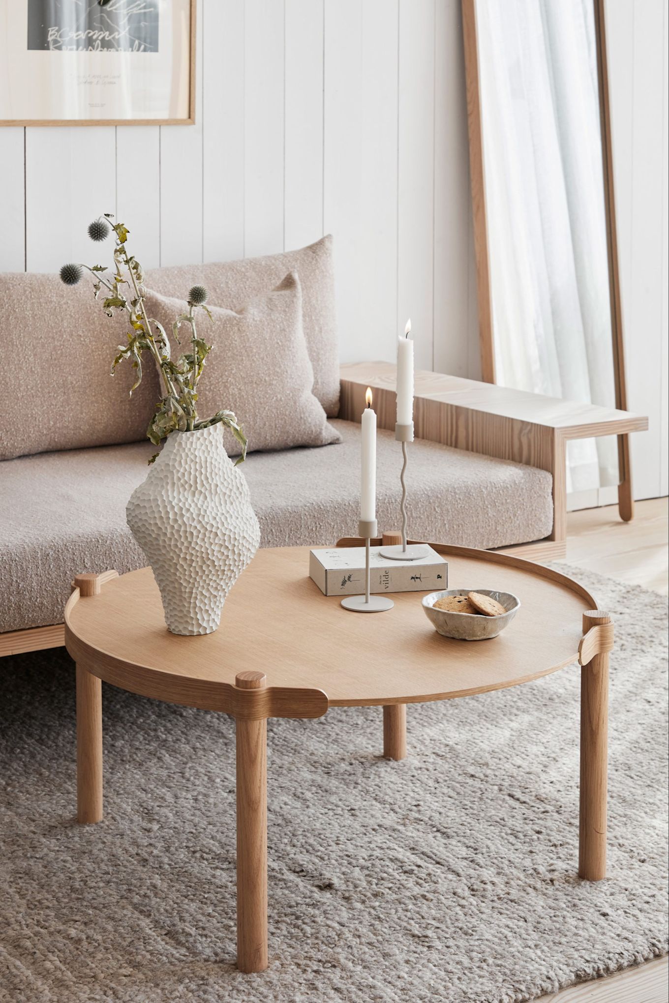 A cream-coloured Scandinavian living room with products from Cooee Design’s range including the Woody coffee table, the Isla vase and the Curve candle holder. 