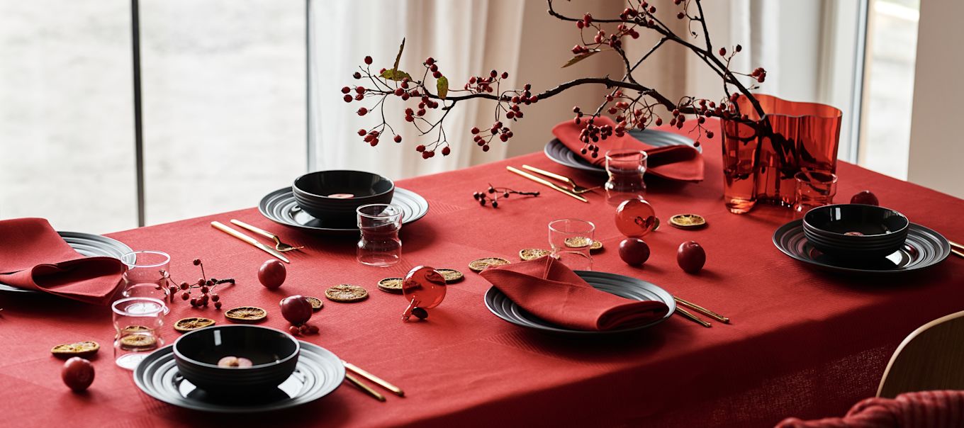 A modern red and grey Christmas table setting with Lines porcelain from NJRD, red linen napkins and a striking red table setting also from NJRD. 