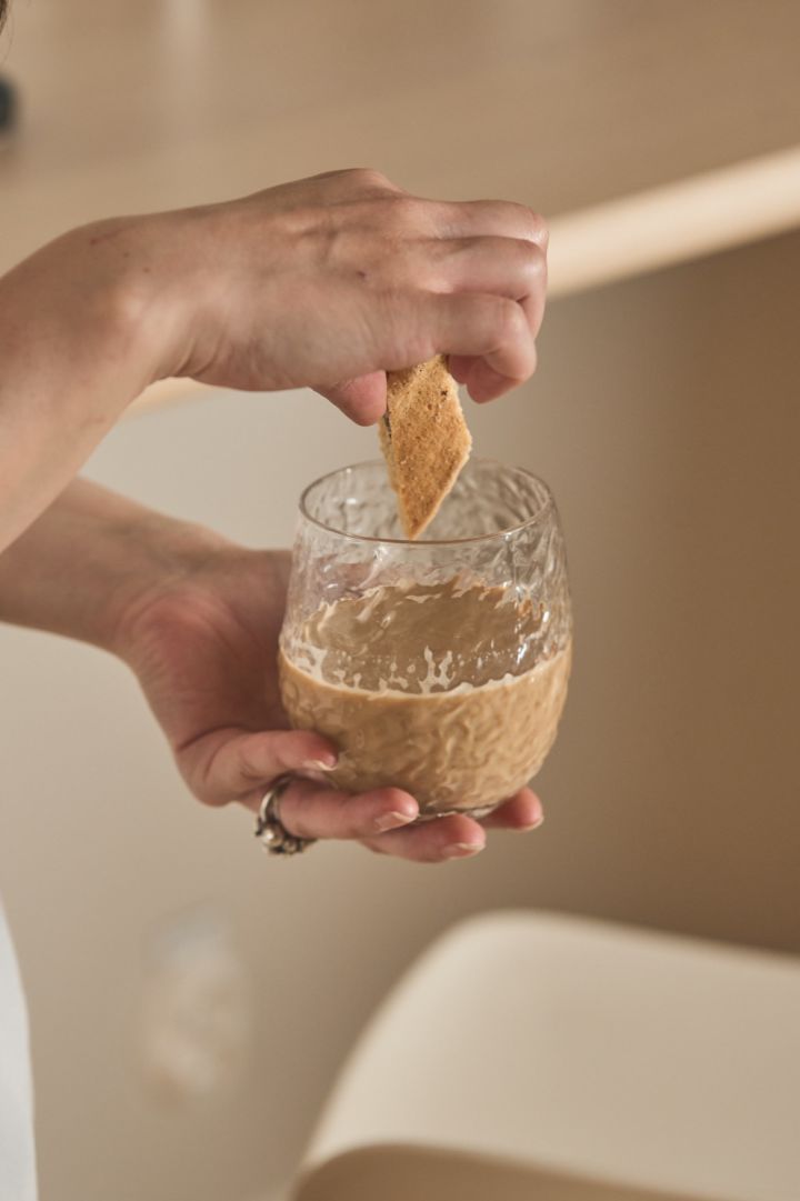 The Swan glass from Byon is a subtle nod at the textured material trend in autumn 2024, here you see a hand dunking a cookie in coffee in the Swan glass. 