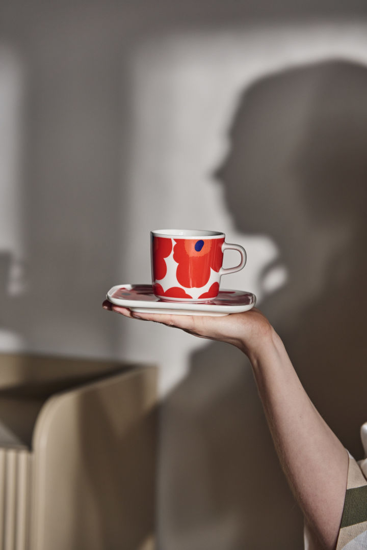 A colourful Marimekko mug held in the palm of a hand, a unique and cosy Christmas gift idea. 