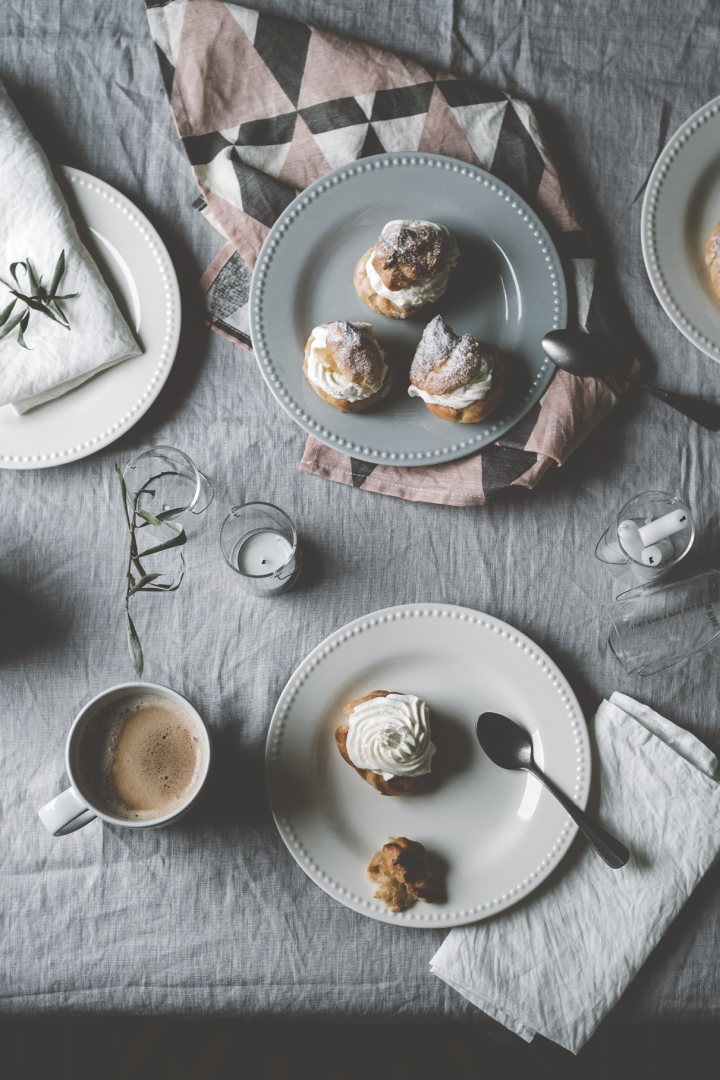 Here you can see @kohlundkimchi's Semlor standing on a table on different coloured plates from the Dots collection by Scandi Living, accompanied by a cup of coffee.