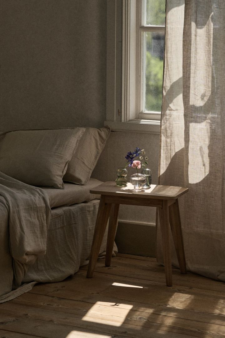 Mini Midsummer vases from Orrefors placed in a group on the bedside table. 