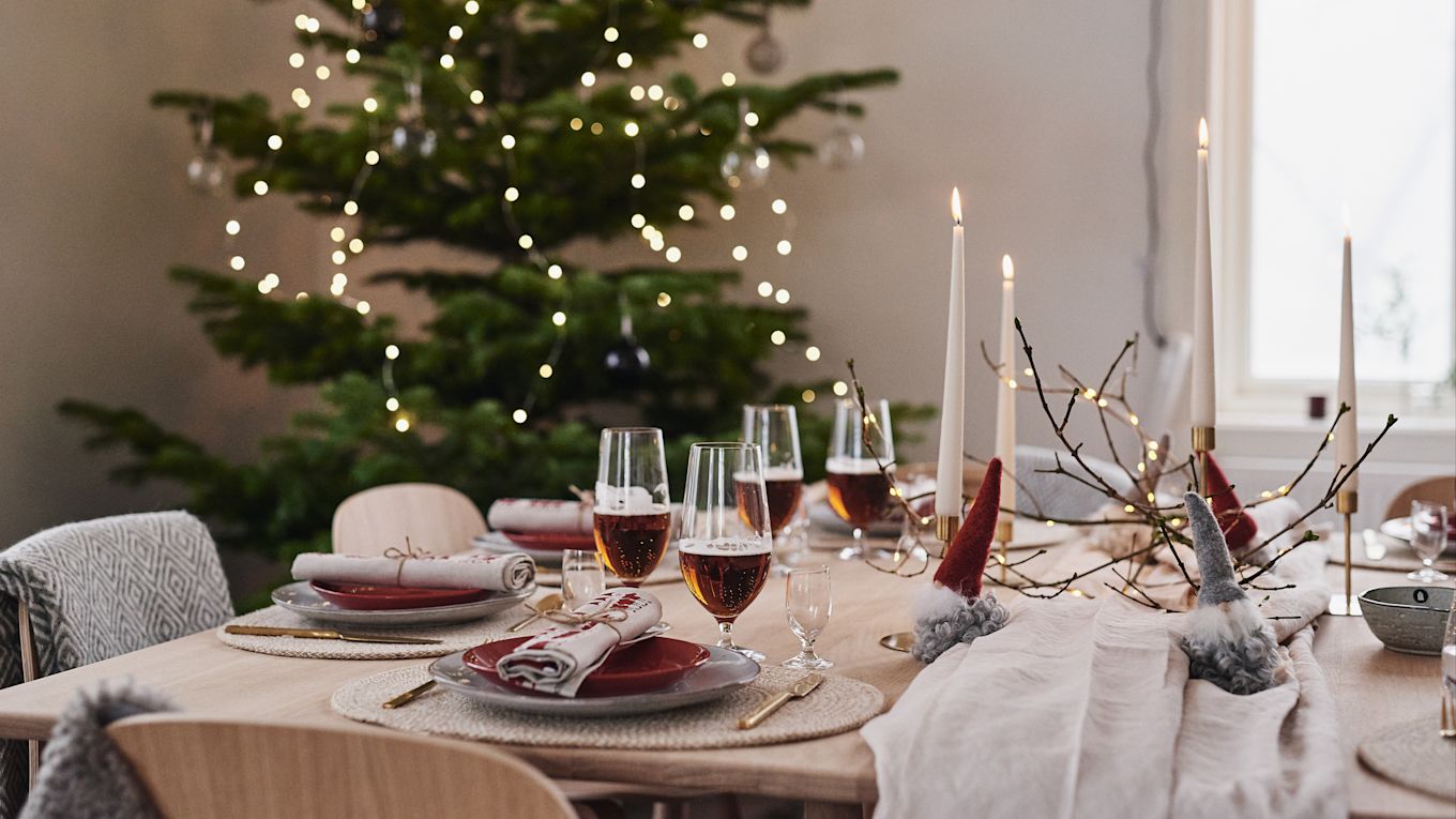 A beautiful Christmas table decoration in red and adorable Santa Clauses made of wool.