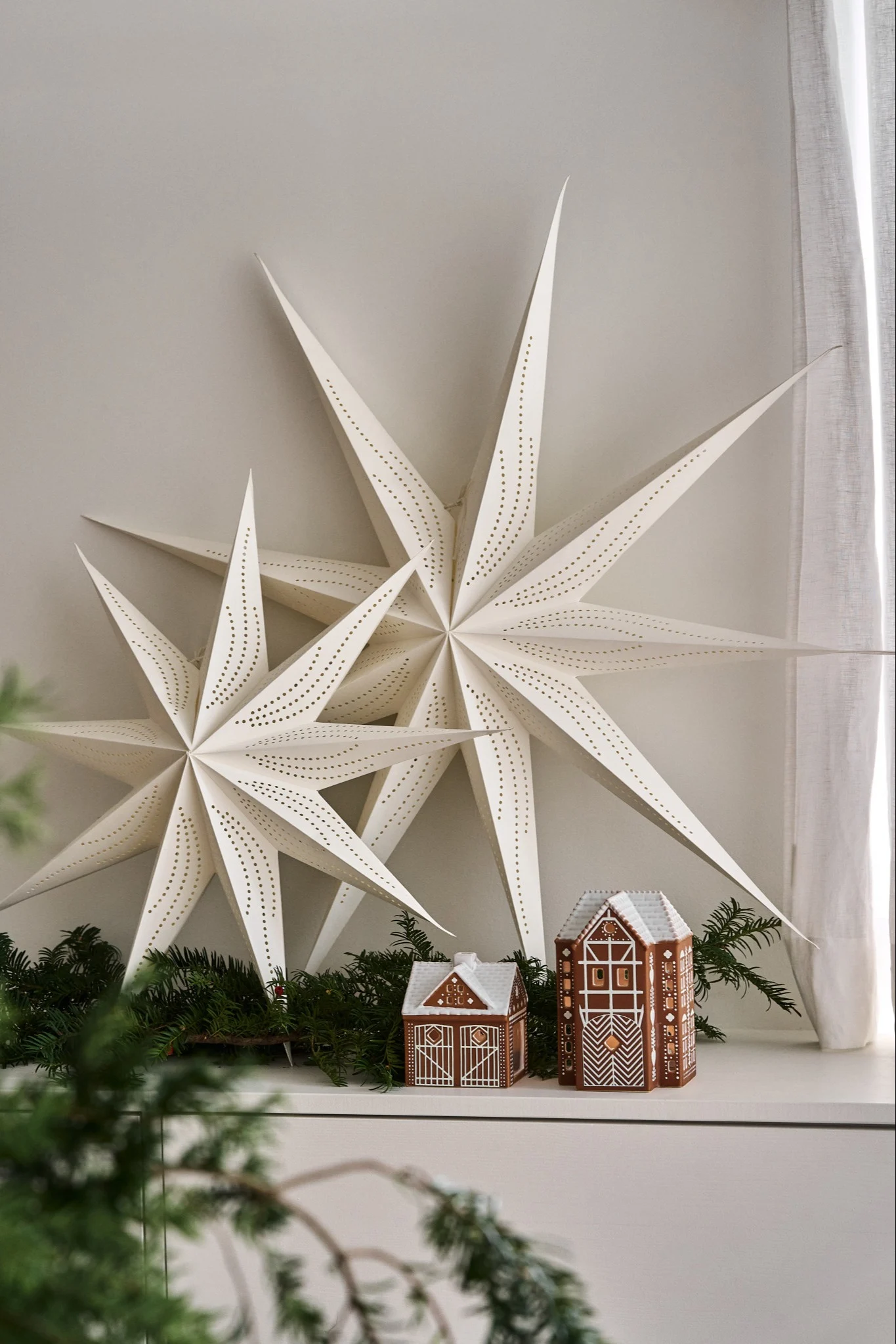 Minimalist Christmas decor with paper Christmas stars hanging from the ceiling of a home.